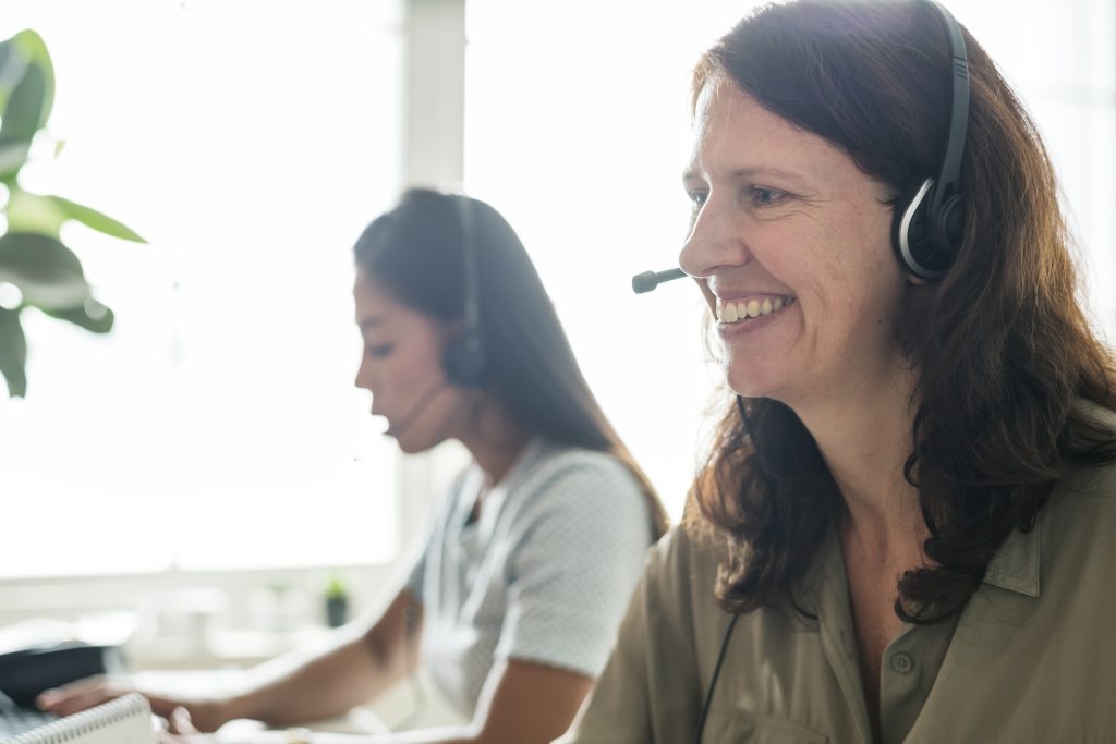 Brown haired lady smiling and talking on headset